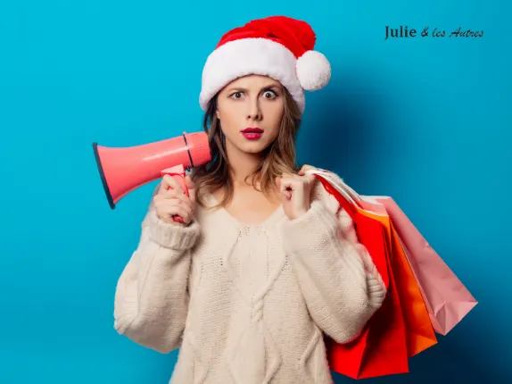 Photo d'un femme tenant un mégaphone, elle porte un bonnet de noel et des sacs dans sa main