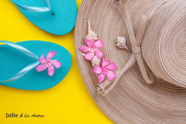 Photo d'une paire de tong avec un chapeau sur un sol jaune